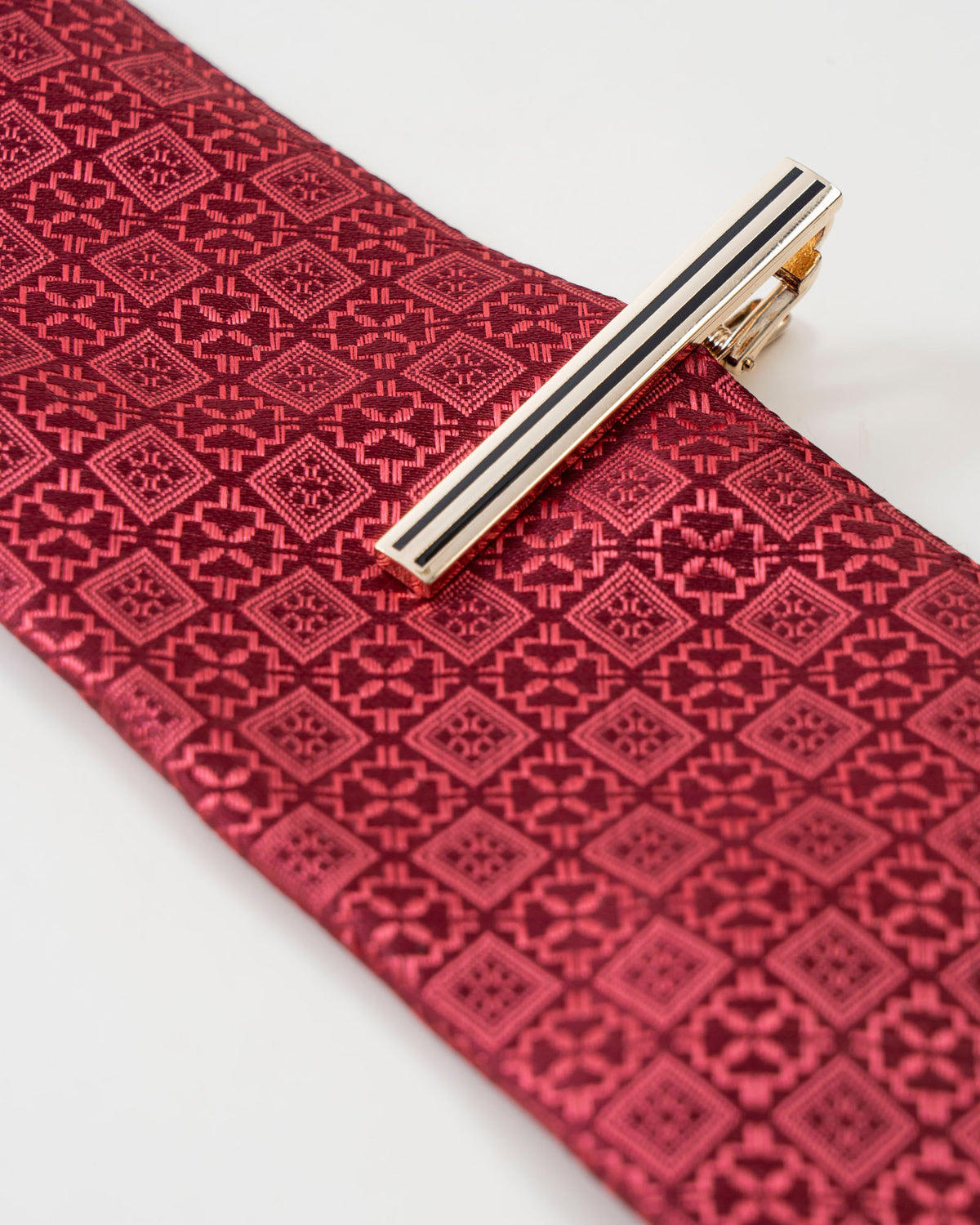 Black stripe gold-tone tie clip close-up
