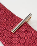 Black stripe gold-tone tie clip shown with a patterned tie
