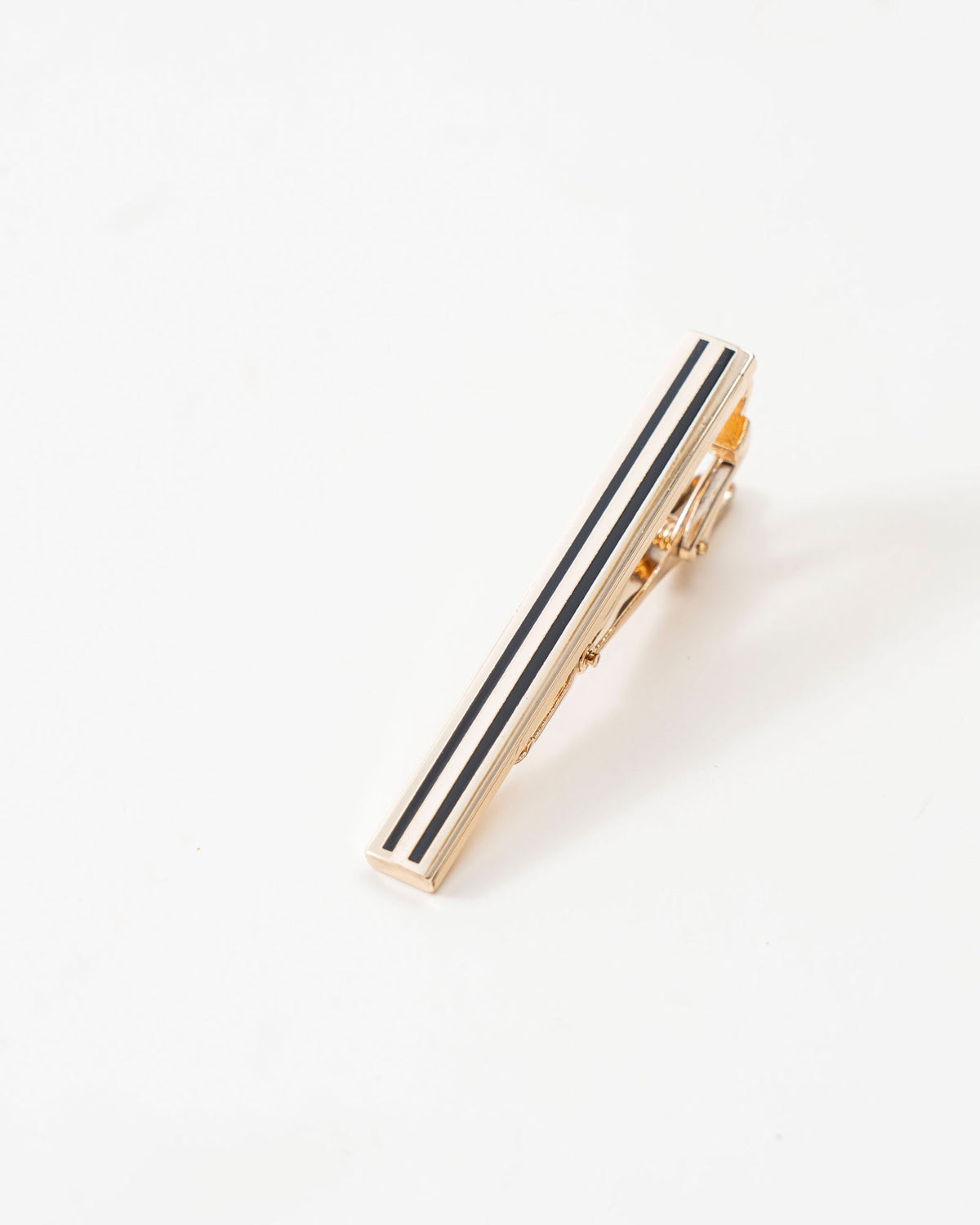 Black stripe gold-tone tie clip styled with a patterned tie