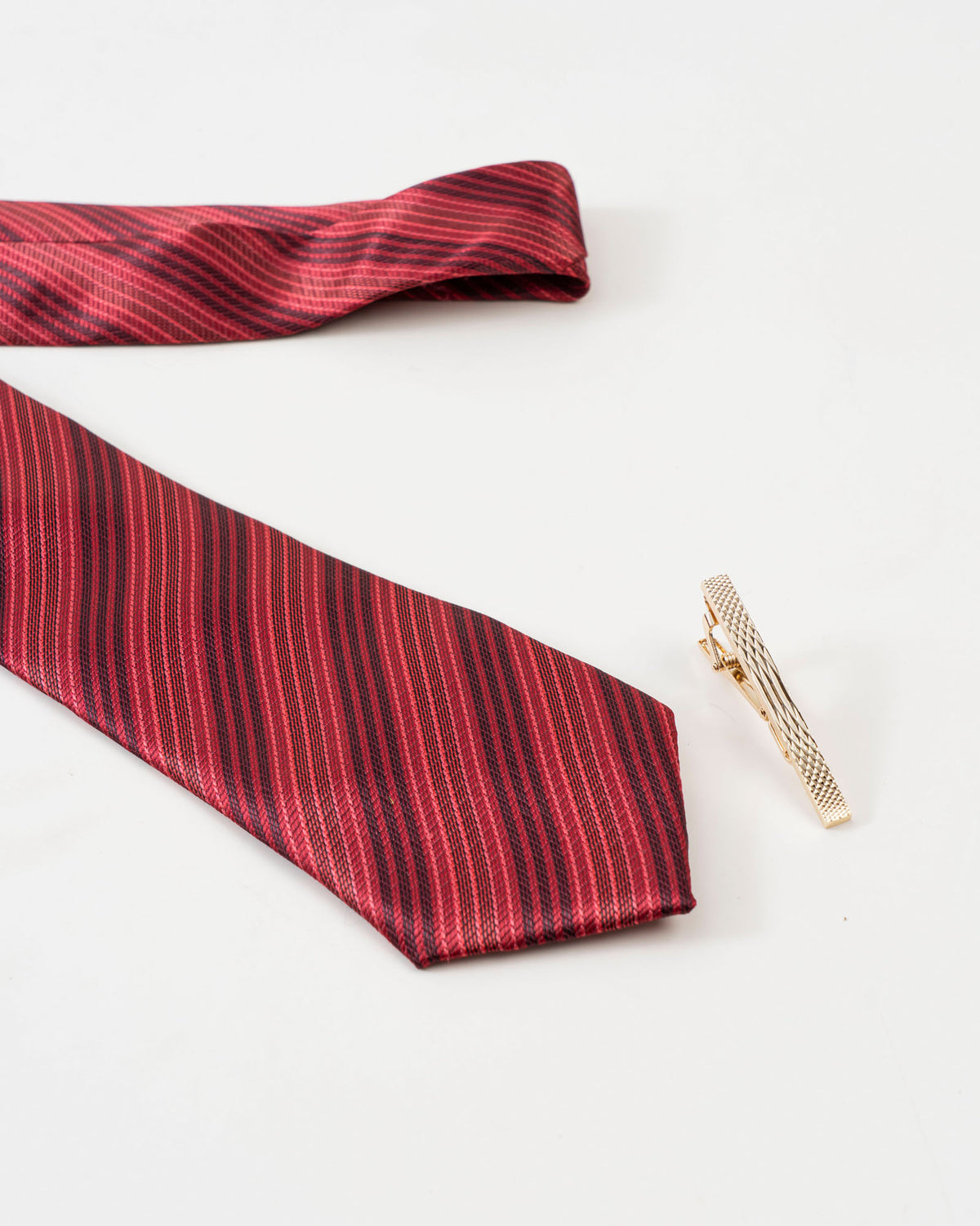 Diamond-textured tie clip styled with a red patterned tie