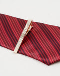 Diamond-textured tie clip attached to a patterned formal tie