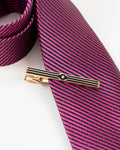 Black stripe gold-tone tie clip close-up