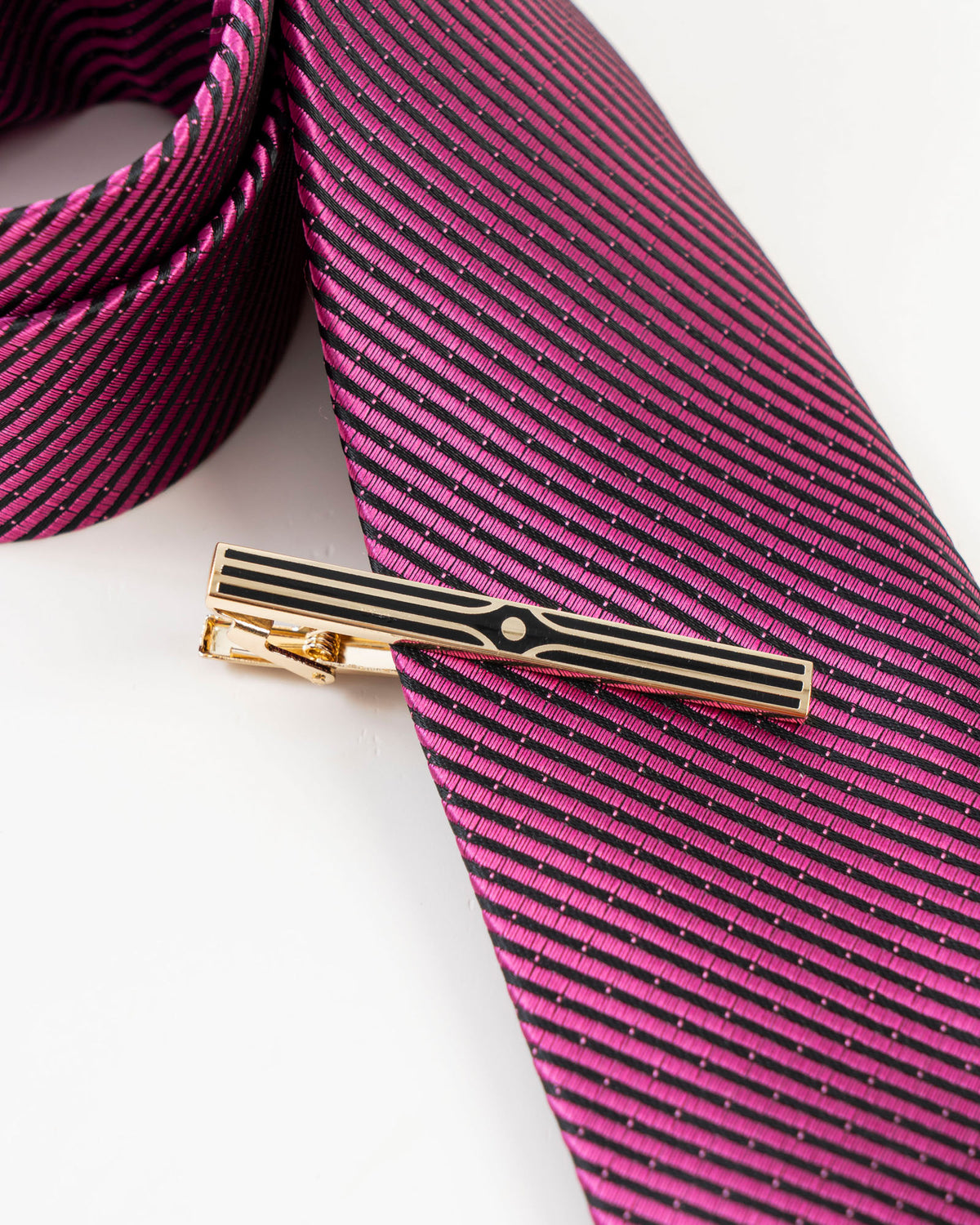 Black stripe gold-tone tie clip close-up