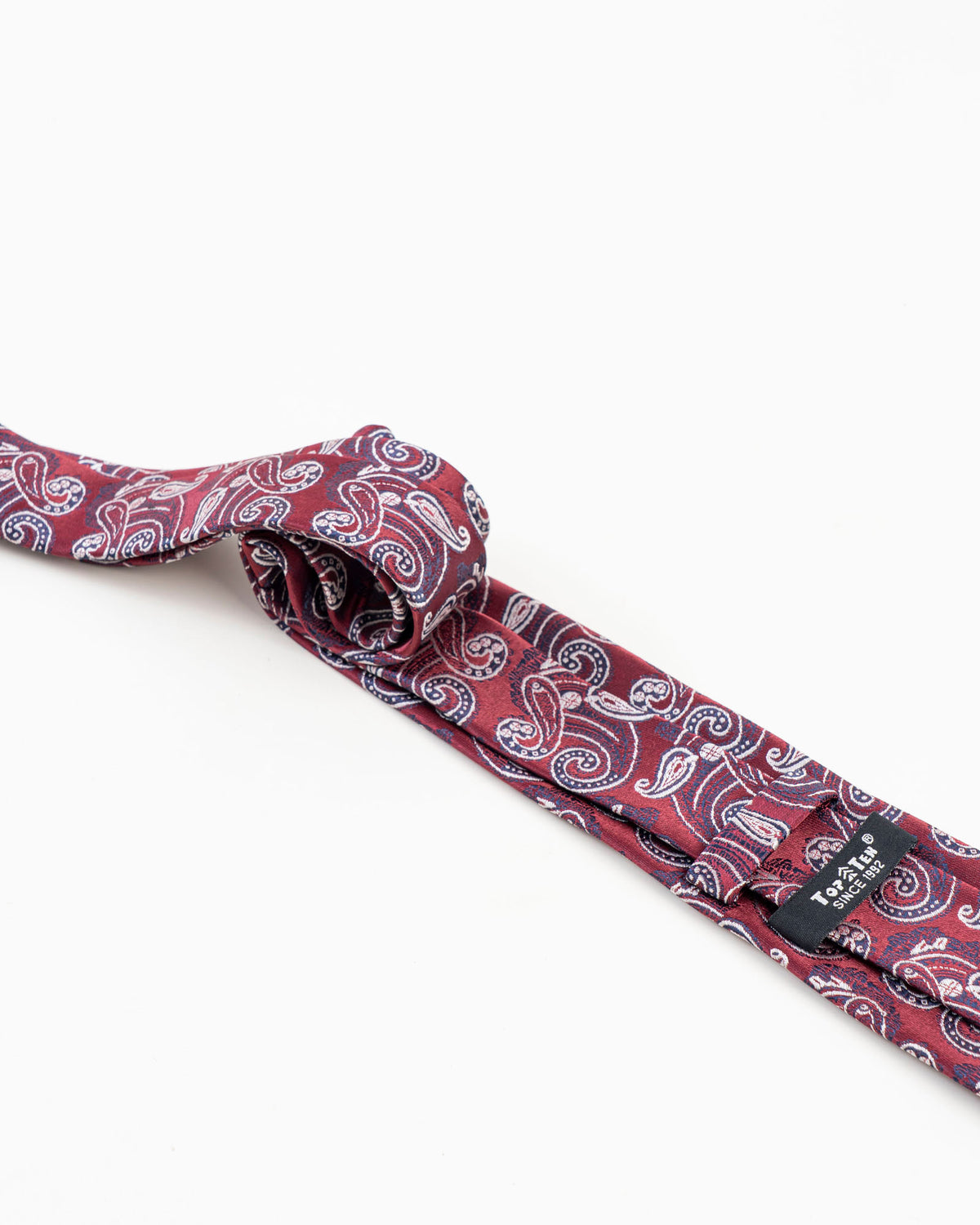 Reverse detail of burgundy paisley patterned tie
