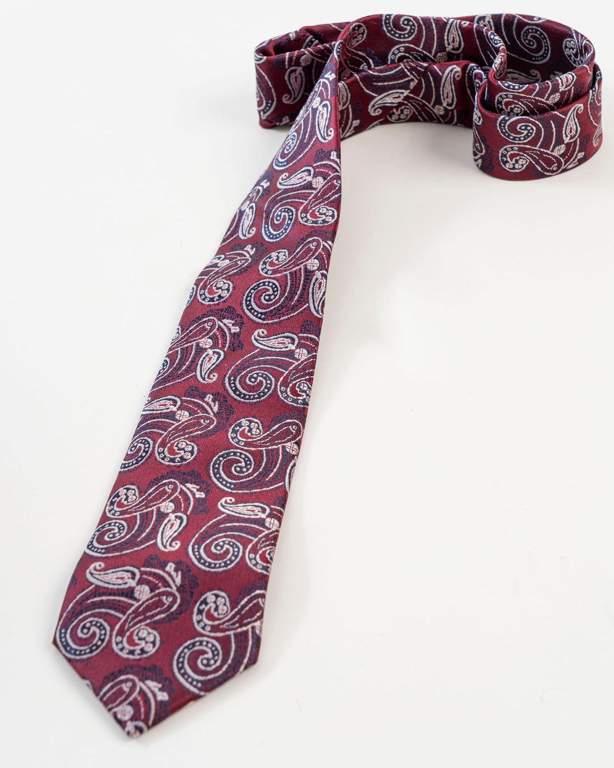 Burgundy paisley tie displayed with matching accessories