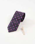 Classic gold-tone tie clip shown with a black and purple dotted tie