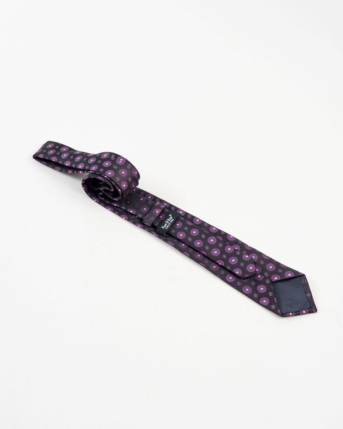 Black and purple circular patterned tie with matching pocket square