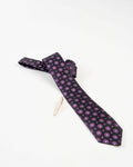 Classic gold-tone tie clip attached to a patterned formal tie