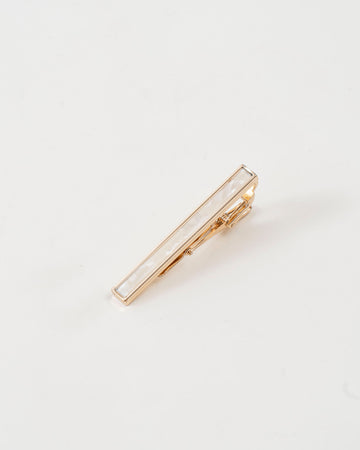 Gold-tone tie clip paired with a black and purple dotted tie